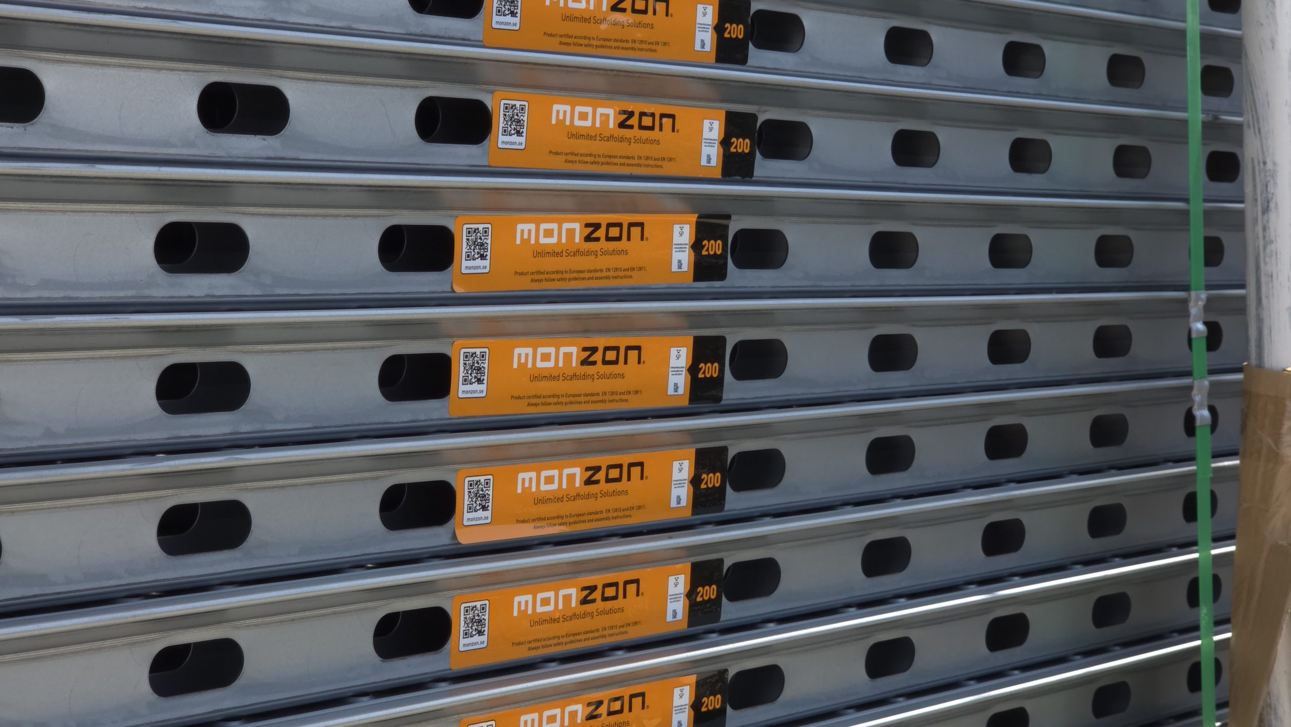 Close-up of stacked MonZon scaffolding platforms with orange product labels