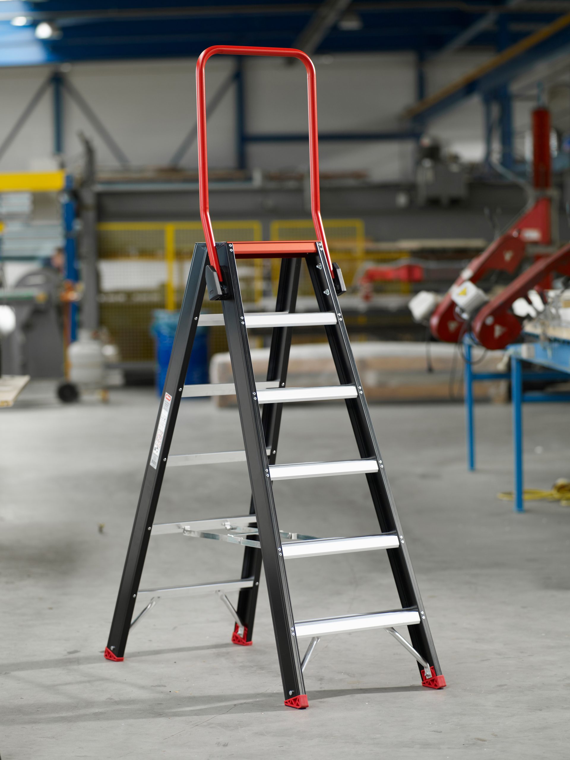 Altrex Taurus double-sided professional stepladder with red handrail in a workshop